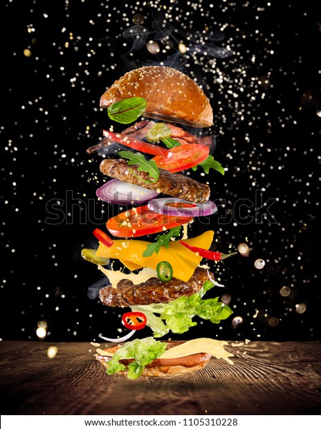 Big tasty\
home made burger with flying\
ingredients.