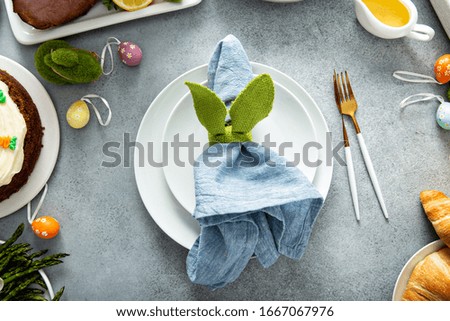 Big traditional Easter brunch with ham, quiche lorraine and carrot cake and place setting
