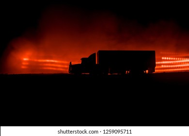 Big truck wagon rides on the road outside the city at night with foggy background. Decoration. Selective focus