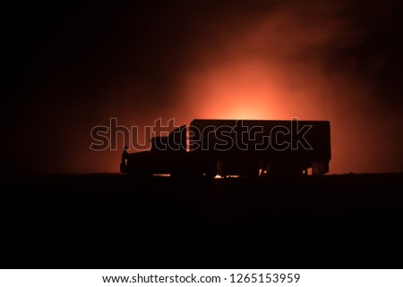 Big truck wagon rides on the road outside the city at night with foggy background. Decoration. Selective focus