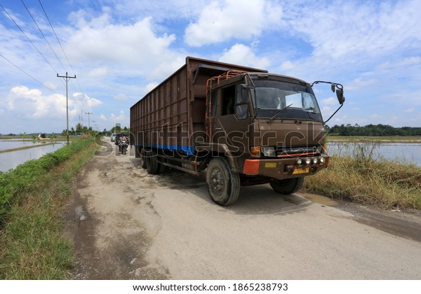 Big trucks go through the\
damaged road in Simalungun, North Sumatra, Indonesia. September\
20,2020.