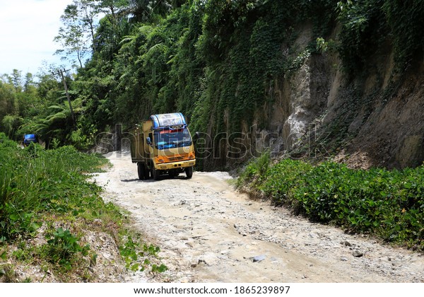 Big trucks go through the\
damaged road in Simalungun, North Sumatra, Indonesia. September\
20,2020.
