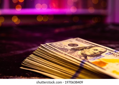 Big wad money hundred dollar bills on pink background in macro with bokeh. Theme of cash settlement in brothel or casino. USD with copy space place in purple lighting and image of President Franklin - Shutterstock ID 1970638409
