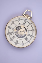 Big Wall Clock In The Form Of An Antique Pocket Watch On A Lavender Background