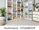 Big wardrobe with clothes and chest of drawers in dressing room