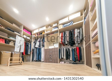 Big wardrobe with different clothes for dressing room