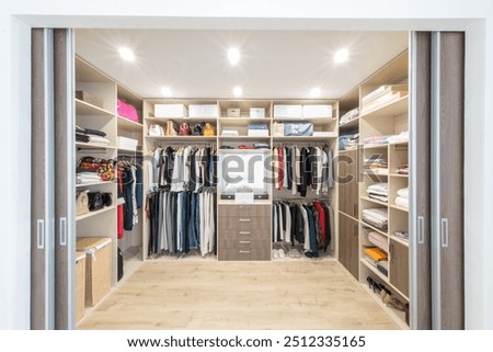 Big wardrobe with different clothes for dressing room