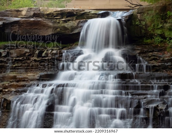 Big waterfall in the forest.\
Solid rock and flowing water compete for space at Upper River\
Falls