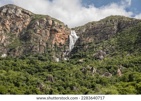 Big waterfall partially cover by a valley in Bahia, Brazil
