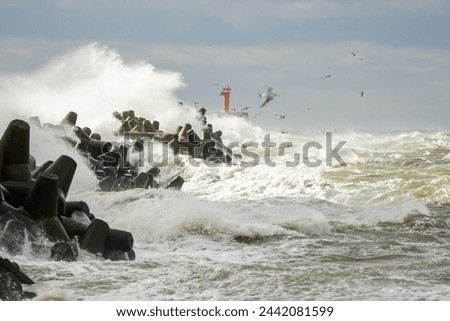 Big wave breaking on breakwater, stormy sea, crashing waves, wave splashing, bad weather, hurricane season, coastal storm
