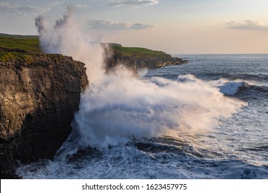 Big waves crashing against the cliffs at sunset - Powered by Shutterstock