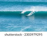 Big Waves crashing creating white foam that vaporises in the air. Sopelana beach near Bilbao. Two surfers ride the same wave together. Day of relaxation and tranquility with wind and nice colors.