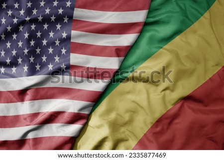 big waving colorful flag of united states of america and national flag of republic of the congo . macro