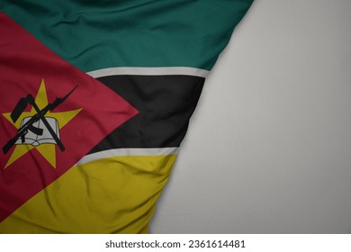 big waving national colorful flag of mozambique on the gray background. macro