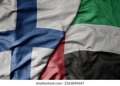 big waving national colorful flag of finland and national flag of united arab emirates . macro