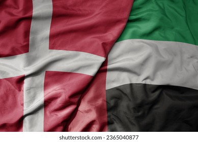 big waving national colorful flag of denmark and national flag of united arab emirates . macro