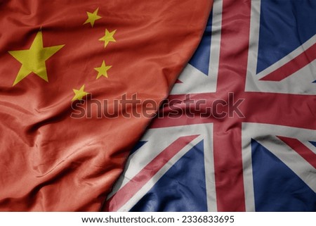 big waving national colorful flag of china and national flag of great britain . macro