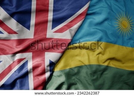 big waving national colorful flag of great britain and national flag of rwanda . macro