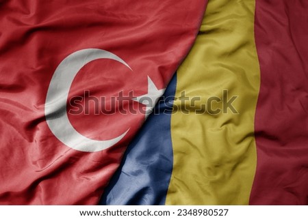 big waving national colorful flag of turkey and national flag of romania . macro
