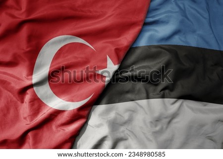 big waving national colorful flag of turkey and national flag of estonia . macro