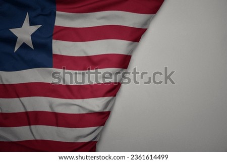 big waving national colorful flag of liberia on the gray background. macro