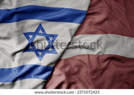 big waving national colorful flag of israel and national flag of latvia . macro
