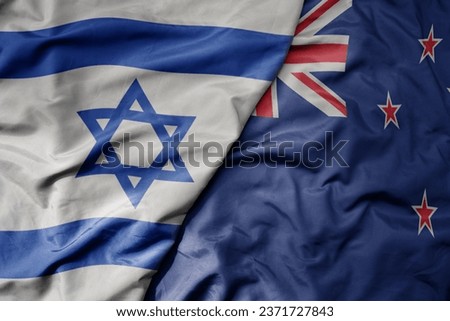big waving national colorful flag of israel and national flag of new zealand . macro