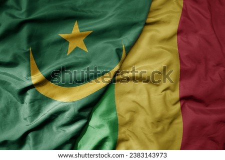 big waving national colorful flag of mauritania and national flag of mali . macro