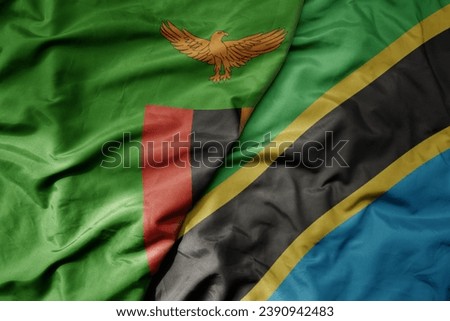 big waving national colorful flag of tanzania and national flag of zambia . macro