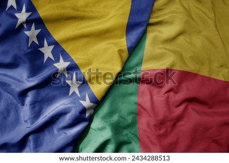 big waving national colorful flag of benin and national flag of bosnia and herzegovina. macro