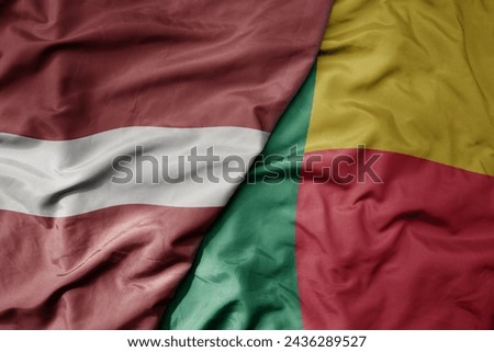 big waving national colorful flag of benin and national flag of latvia. macro