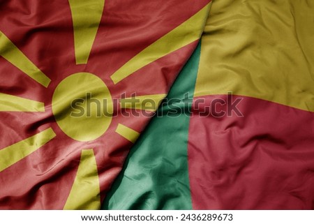 big waving national colorful flag of benin and national flag of macedonia . macro