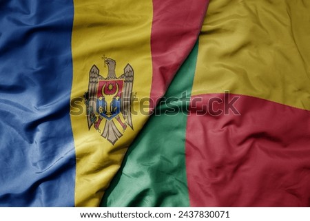 big waving national colorful flag of benin and national flag of moldova . macro