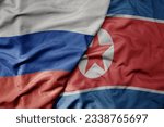 big waving realistic national colorful flag of russia and national flag of north korea . macro