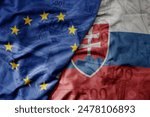 big waving realistic national colorful flag of european union and national flag of slovakia on a euro money banknotes background. finance concept.