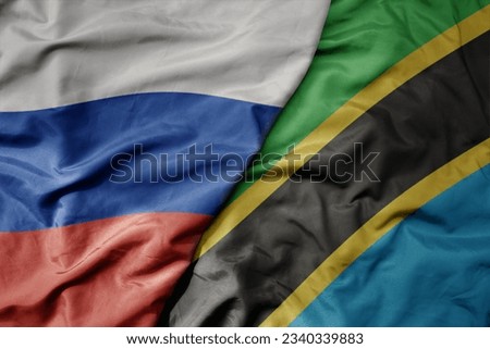 big waving realistic national colorful flag of russia and national flag of tanzania . macro