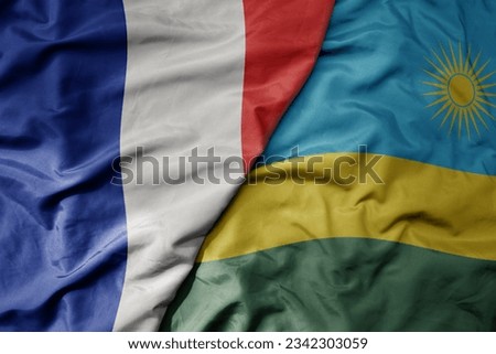 big waving realistic national colorful flag of france and national flag of rwanda . macro
