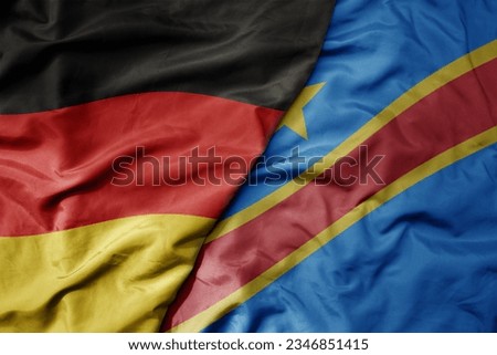 big waving realistic national colorful flag of germany and national flag of democratic republic of the congo . macro