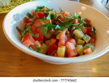 Big White Ceramic Bowl With Fresh Vegetable Salad Made Of Tomato, Cucumber And Parsley - On Wooden Table At Restaurant