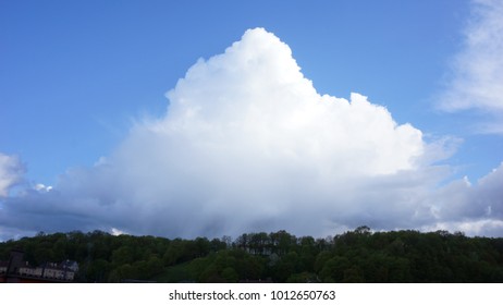 Big white cloud over the forest and town