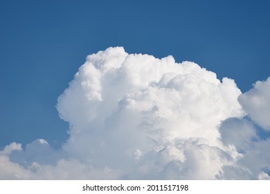 Big White Fluffy Clouds On Clear Blue Sky. Cloudy Sky Background With Copy Space. Cumulus Cloud Close Up