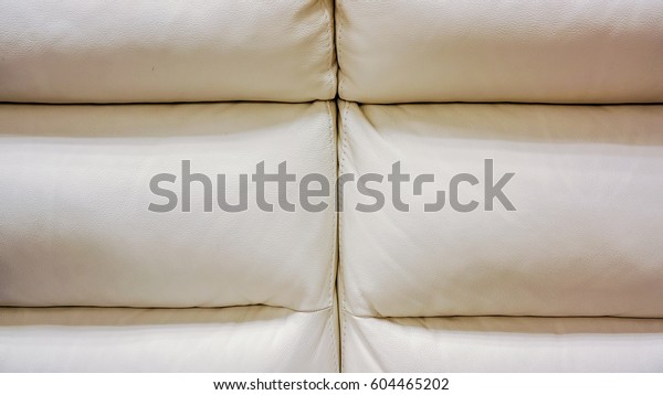 big white lather\
soft sofa divided into three vertical sections for comfortable\
waiting on reception or in waiting room in big office. close up of\
white sofa in a waiting\
room
