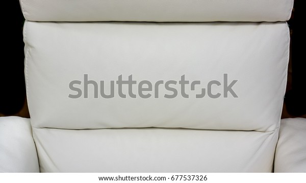 big white lather soft sofa\
divided into three sections for comfortable waiting on reception or\
in waiting room in big office. close up of white sofa in a waiting\
room