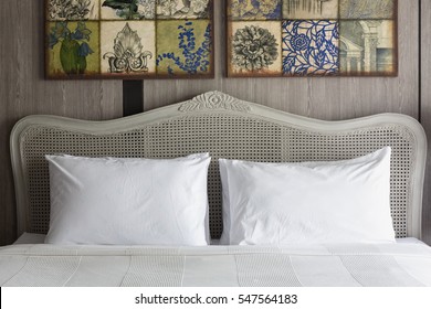 Big White Pillows On A White Luxury Bed With Rattan Headboard.