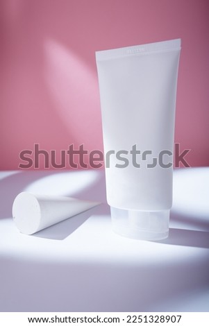 Big white tube of hair conditioner mockup, no label template, pink backdrop in harsh light. Care Korean cosmetics container