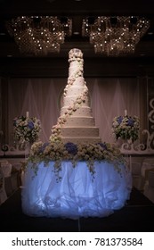 Big White Wedding Cake In Ballroom Hall Decoration With Flower Cream In Vintage Color Tone 