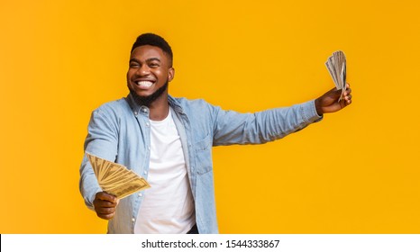 Big Win. Overjoyed African American Man Holding A Lot Of Money In Both Hands On Yellow Background, Panorama