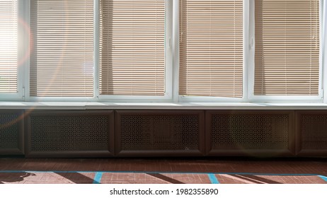 Big Windows With Closed Sunblinds In Empty School Gymnasium Hall With Wooden Floor