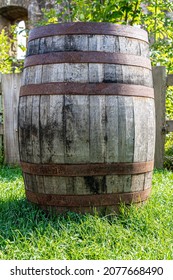 Big wooden wine cask with rusted barrel hoops on the green grass