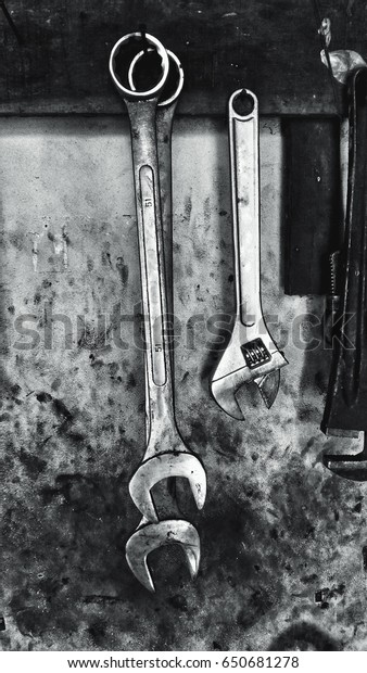 big wrenches in messy garage work shop, low saturation\
high contrast 